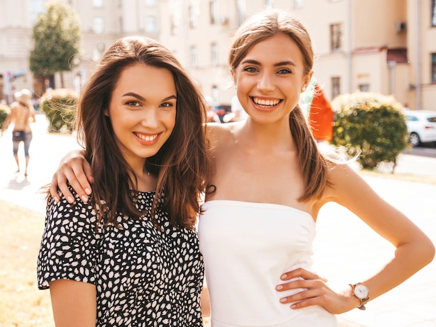 Dos jóvenes hermosas chicas hipster sonrientes en ropa de moda de verano