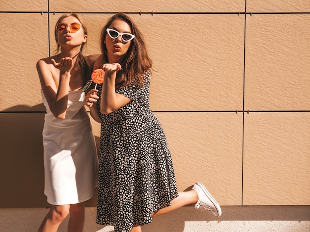 Dos jóvenes hermosas chicas hipster sonrientes en vestido de moda de verano.