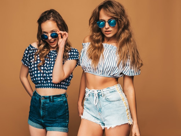 Dos jóvenes hermosas chicas sonrientes en ropa de verano de moda y gafas de sol. sexy mujer despreocupada posando. modelos positivos