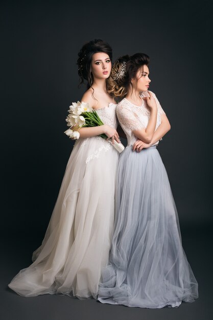 Dos jóvenes hermosas mujeres elegantes en vestidos de novia