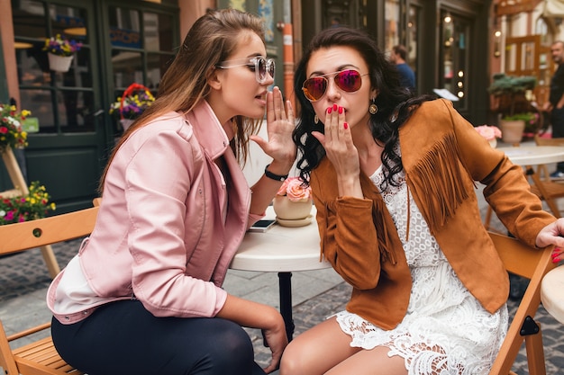 Dos jóvenes hermosas mujeres hipster sentados en el café