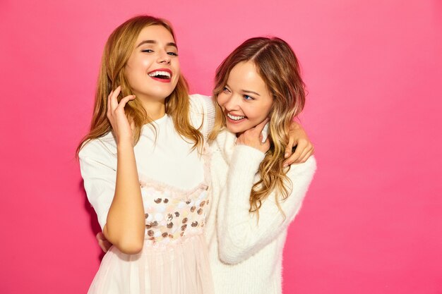Dos jóvenes hermosas mujeres sonrientes en ropa blanca de moda de verano