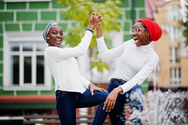 Dos jóvenes mujeres musulmanas africanas altas y delgadas, atractivas, modernas y modernas, con hiyab o pañuelo en la cabeza con turbante, posaron juntas