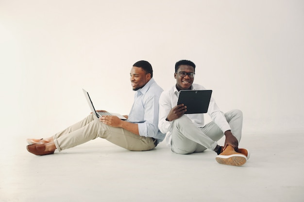 Dos jóvenes negros que trabajan juntos y usan la computadora portátil