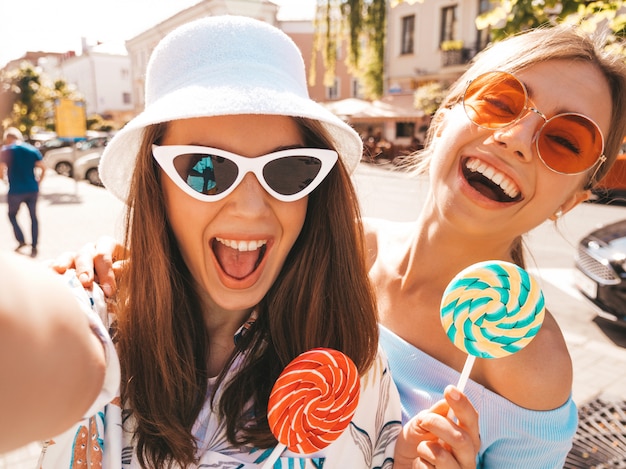 Dos jóvenes sonrientes mujeres hipster en ropa casual de verano.