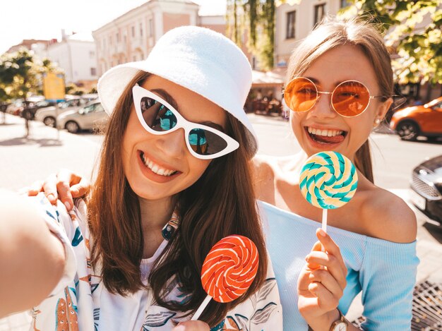 Dos jóvenes sonrientes mujeres hipster en ropa casual de verano.