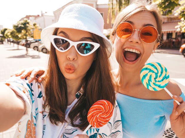 Dos jóvenes sonrientes mujeres hipster en ropa casual de verano.