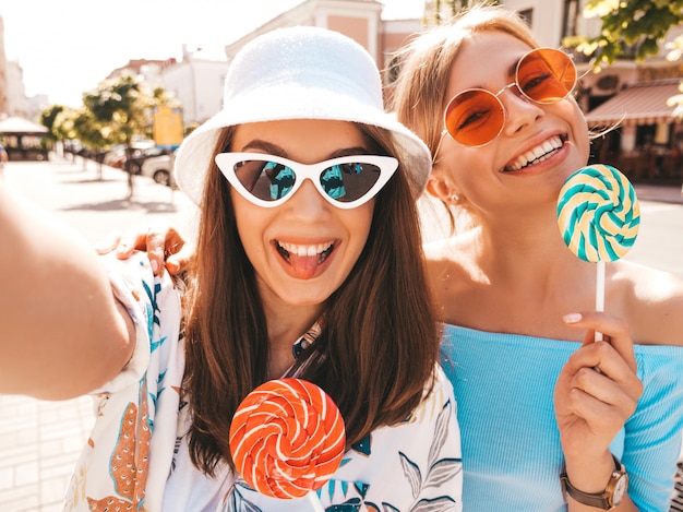 Dos jóvenes sonrientes mujeres hipster en ropa casual de verano.