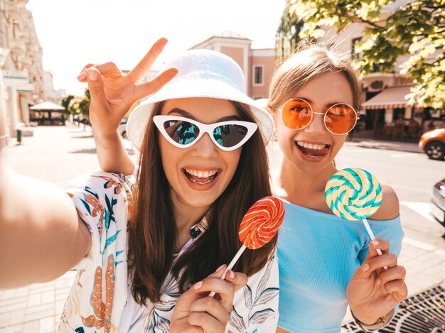 Dos jóvenes sonrientes mujeres hipster en ropa casual de verano.