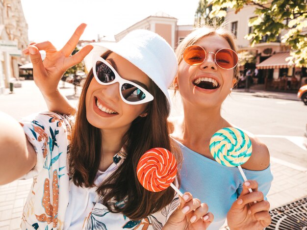 Dos jóvenes sonrientes mujeres hipster en ropa casual de verano.