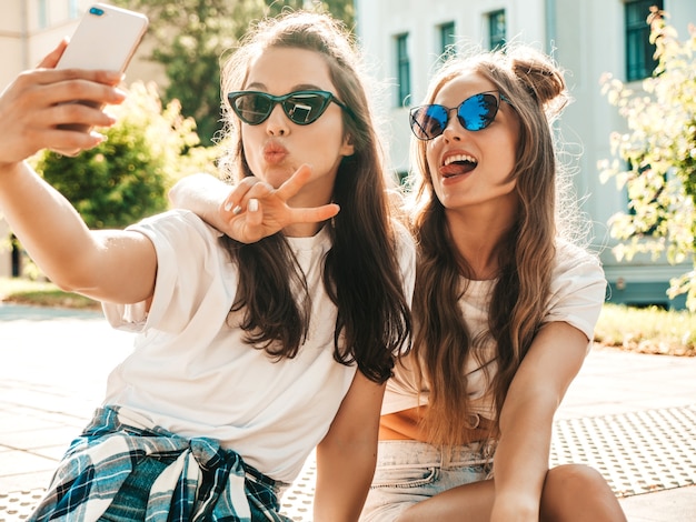 Dos jóvenes sonrientes a mujeres hipster en ropa de verano