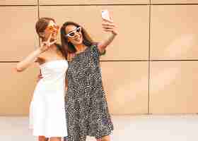 Foto gratuita dos jóvenes sonrientes mujeres hipster en ropa de verano.