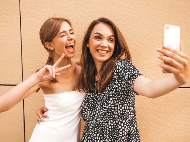 Dos jóvenes sonrientes mujeres hipster en ropa de verano.