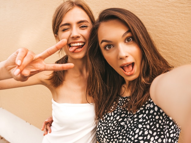 Dos jóvenes sonrientes mujeres hipster en ropa de verano.