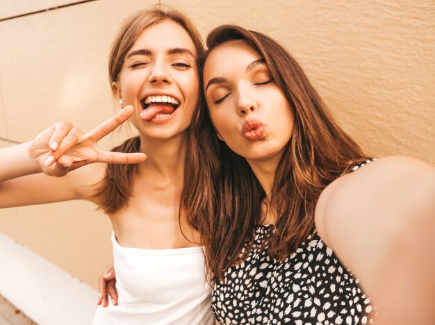 Dos jóvenes sonrientes mujeres hipster en ropa de verano.