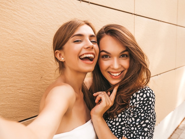 Dos jóvenes sonrientes mujeres hipster en ropa de verano.