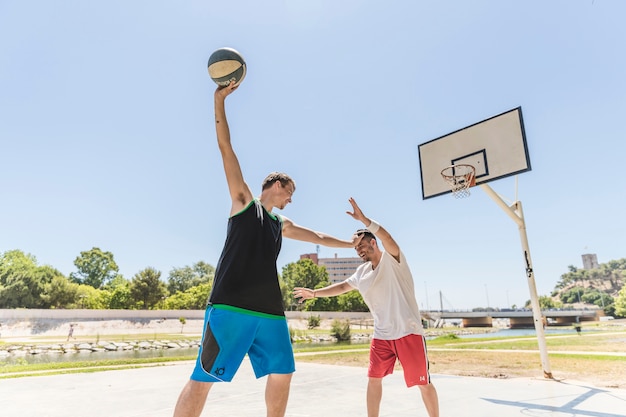 Dos jugadores de baloncesto practicando en la cancha al aire libre