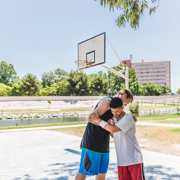 Foto gratuita dos jugadores de baloncesto con un saludo deportivo antes del entrenamiento