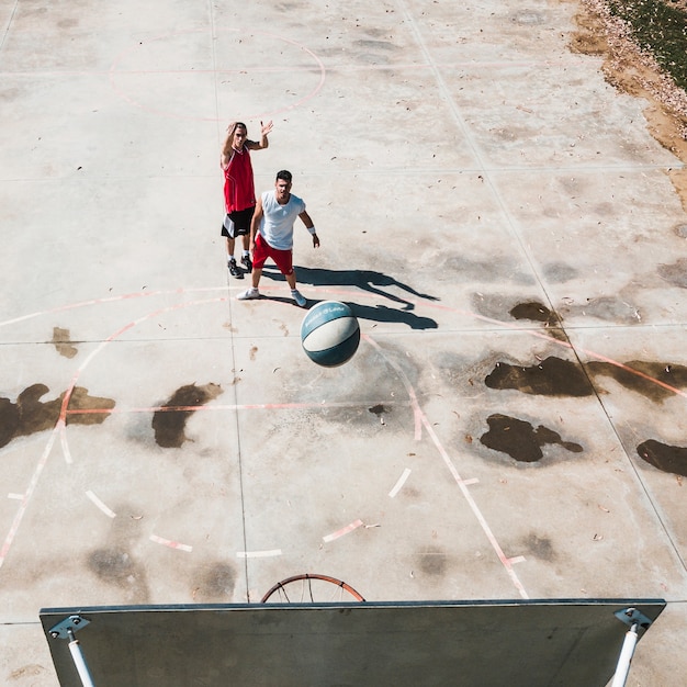 Dos jugadores masculinos practicando baloncesto