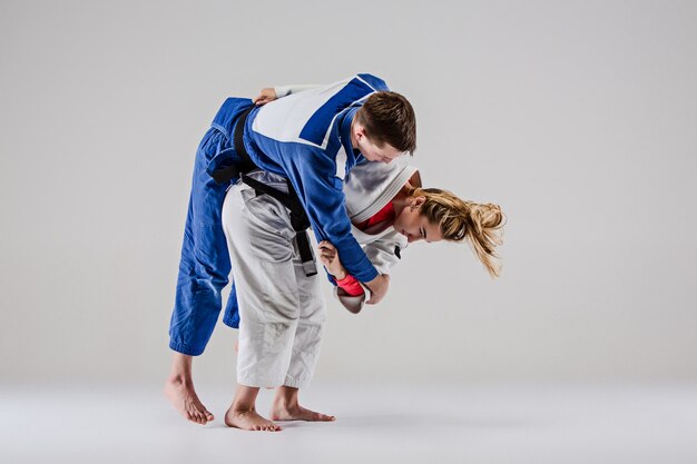 Los dos luchadores de judokas posando en gris