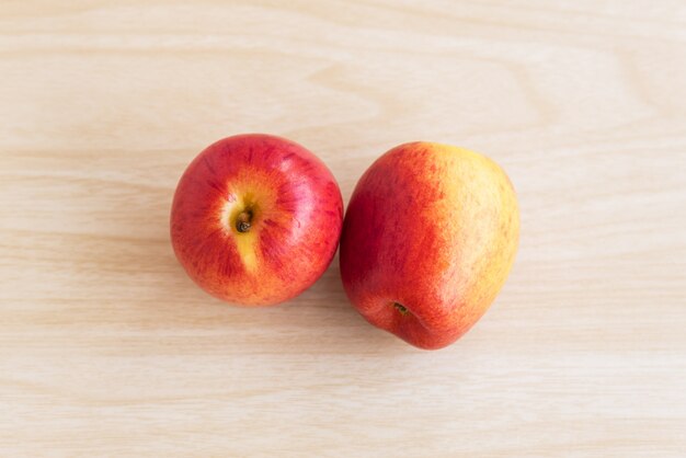 Dos manzanas están en la mesa de madera