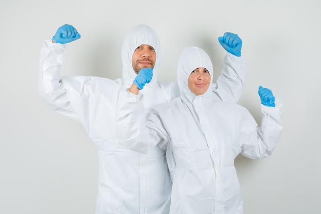 Dos médicos mostrando gesto de ganador en trajes de protección