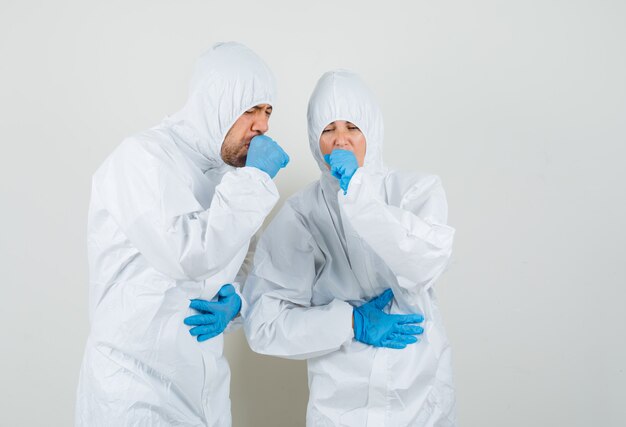 Dos médicos que sufren de tos en trajes protectores