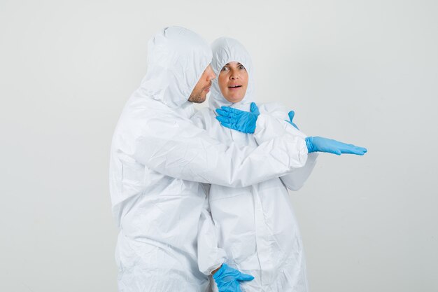 Dos médicos en trajes de protección, guantes mirando algo inesperado