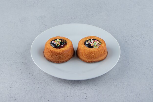 Dos mini pasteles con gelatina colocados en un plato blanco. Foto de alta calidad