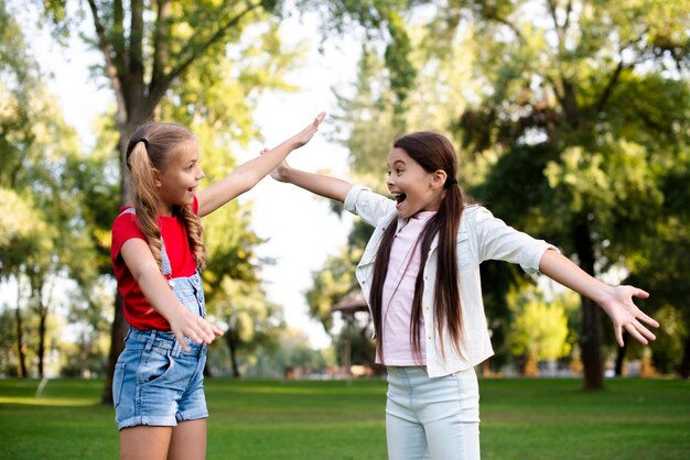 Dos muchachas felices estirando sus manos