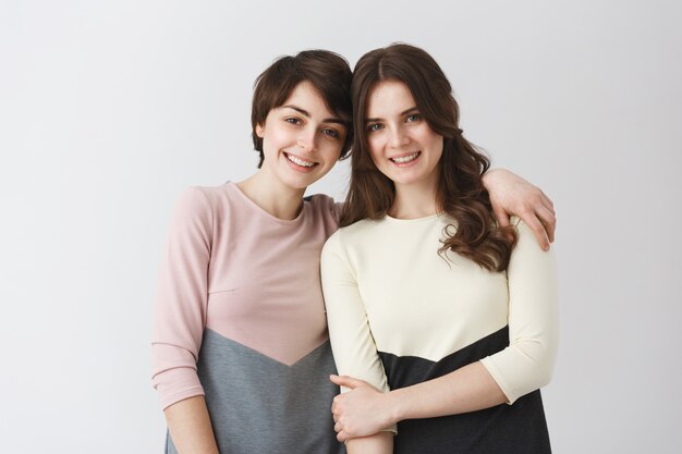 Dos muchachas hermosas y felices siendo amigas desde la infancia, posando para el álbum de fotos familiar antes de mudarse a otra ciudad para estudiar.