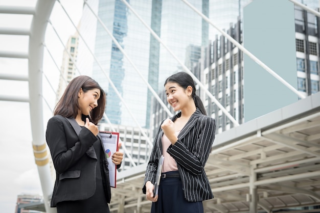 Dos mujer de negocios de pie y discutir en frente de la oficina. Concepto de trabajo de negocios.