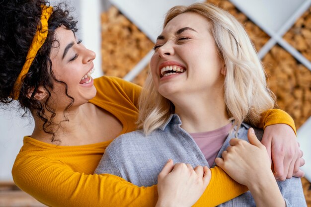 Dos mujeres abrazados riendo juntos
