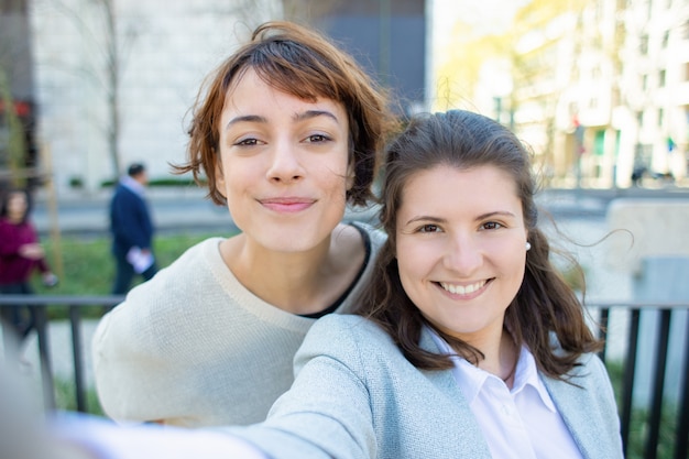 Dos mujeres alegres posando para autorretrato