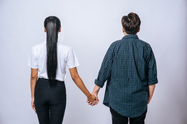 Dos mujeres amorosas de pie y cogidos de la mano.