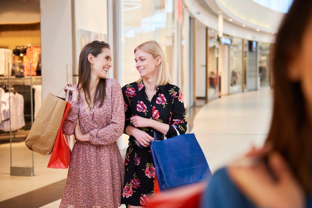 Dos mujeres con bolsas de compras en el centro comercial.