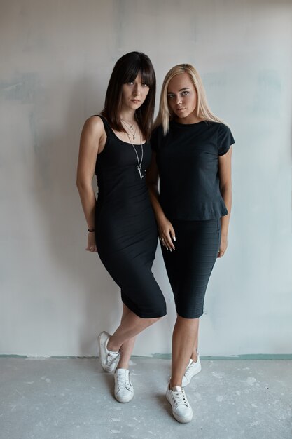 Dos mujeres bonitas en un vestido negro interior