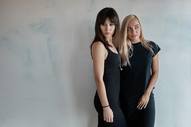 Dos mujeres bonitas en un vestido negro interior