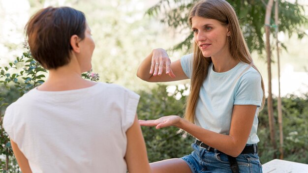 Dos mujeres conversando entre sí mediante lenguaje de señas