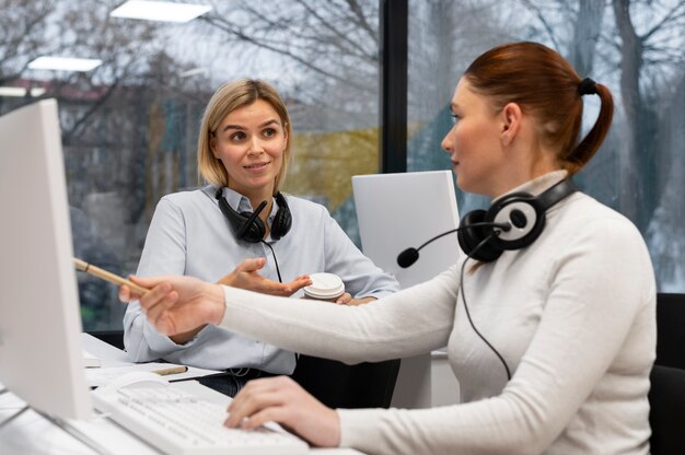 Dos mujeres conversando durante el trabajo en la oficina del centro de llamadas