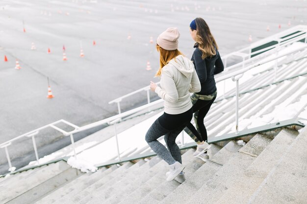 Dos mujeres corriendo en la escalera en el invierno.