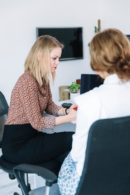 Foto gratuita dos mujeres empresarias trabajando en oficina