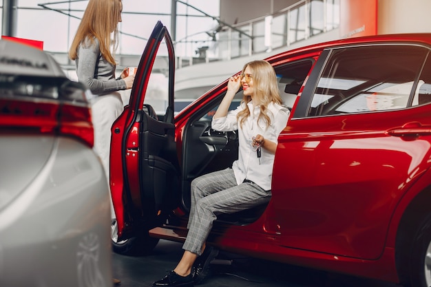 Foto gratuita dos mujeres con estilo en un salón de autos