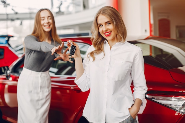 Foto gratuita dos mujeres con estilo en un salón de autos