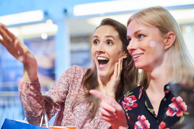 Dos mujeres felices mirando el escaparate