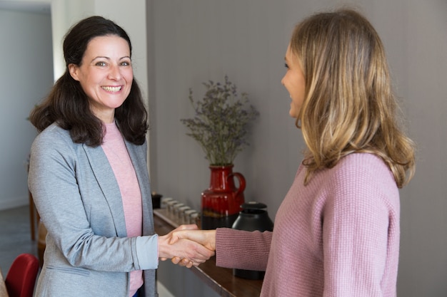 Dos mujeres felices de pie y agitando las manos