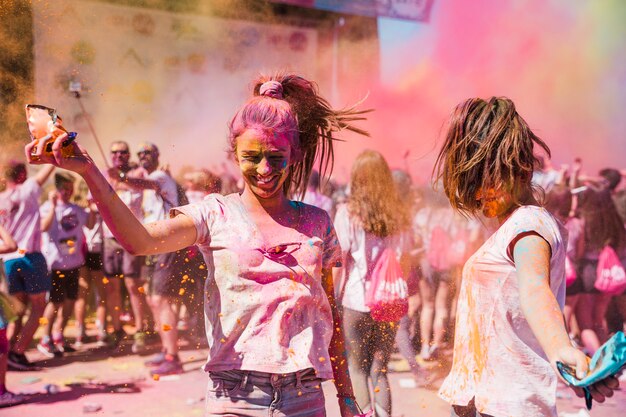 Dos mujeres jóvenes jugando y disfrutando con colores holi.