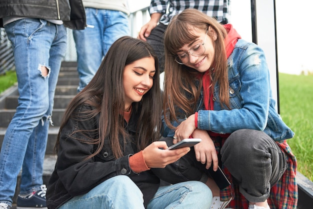 Foto gratuita dos, mujeres jóvenes, mirar teléfono móvil