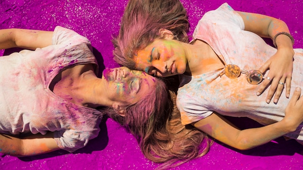 Dos mujeres jóvenes en polvo de color rosa holi