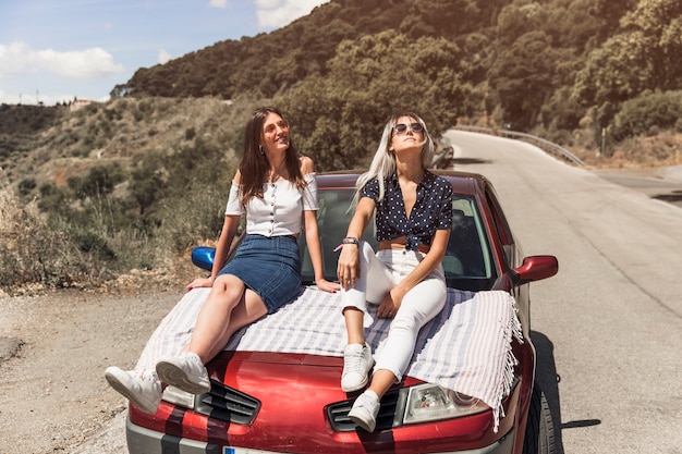 Dos mujeres jóvenes sentados en el coche relajante